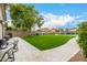 Expansive backyard features lush artificial turf, a spacious stone patio, and mature trees for shade at 528 E Kyle Ct, Gilbert, AZ 85296