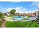 Inviting backyard pool with hammock, lush green grass, lounge chairs, and beautiful desert landscaping at 528 E Kyle Ct, Gilbert, AZ 85296
