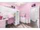 Bright and inviting bedroom with a pink color scheme, showcasing a loft bed with a study area at 528 E Kyle Ct, Gilbert, AZ 85296