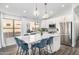 Bright kitchen featuring white cabinets, stainless steel appliances, a marble island with seating, and modern pendant lights at 528 E Kyle Ct, Gilbert, AZ 85296