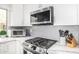 Updated kitchen with stainless steel appliances, white cabinets, and a gray subway tile backsplash at 528 E Kyle Ct, Gilbert, AZ 85296