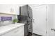 Clean laundry room featuring stacked washer/dryer, white cabinets, and stylish quartz countertops for folding at 528 E Kyle Ct, Gilbert, AZ 85296