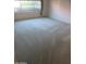 Bedroom featuring plush carpeting, neutral walls, and a window with floral patterned curtains at 6230 S Championship Dr, Chandler, AZ 85249