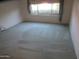 Bedroom featuring plush carpeting, neutral walls, and a window with floral patterned curtains at 6230 S Championship Dr, Chandler, AZ 85249