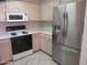 A well-lit kitchen featuring a stainless steel refrigerator, white appliances, and ample counter space at 6230 S Championship Dr, Chandler, AZ 85249