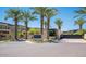 Community entrance featuring lush palm trees and modern architecture under a clear blue sky at 6311 E Phoenician Blvd # 19, Scottsdale, AZ 85251