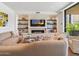 Cozy living room with a stone fireplace, built-in shelves, comfortable sofa, and modern decor at 6311 E Phoenician Blvd # 19, Scottsdale, AZ 85251