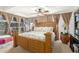 Main bedroom with a large wooden bed, ceiling fan, and natural light from large windows at 7167 E Rancho Vista Dr # 4011, Scottsdale, AZ 85251