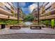 Beautiful courtyard with a tranquil water feature, lush landscaping, seating, and views of the building's exterior at 7167 E Rancho Vista Dr # 4011, Scottsdale, AZ 85251