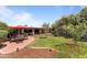 Landscaped backyard featuring patio with umbrella-covered seating and lush green grass at 7611 E Pasadena Ave, Scottsdale, AZ 85250