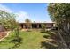 Expansive backyard with well-maintained lawn, brick patio, mature trees, and a relaxing hot tub area at 7611 E Pasadena Ave, Scottsdale, AZ 85250