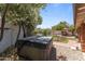 Private backyard featuring a hot tub, lush greenery, and mature trees, offering a serene and relaxing outdoor space at 7611 E Pasadena Ave, Scottsdale, AZ 85250