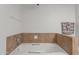 Close-up of a clean, white bathtub with tiled accents in the bathroom at 7611 E Pasadena Ave, Scottsdale, AZ 85250