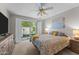 Cozy bedroom featuring large bed, ceiling fan, and sliding door to a private outdoor space at 7611 E Pasadena Ave, Scottsdale, AZ 85250