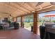 Inviting covered patio with tile flooring, brick columns, ceiling fans, and comfortable seating area overlooking backyard at 7611 E Pasadena Ave, Scottsdale, AZ 85250