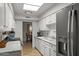 Well-lit kitchen featuring white cabinets and stainless steel appliances at 7611 E Pasadena Ave, Scottsdale, AZ 85250