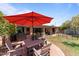Inviting patio area with outdoor dining set under a large umbrella, complemented by lush greenery at 7611 E Pasadena Ave, Scottsdale, AZ 85250