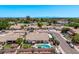 A residential home showcasing a backyard pool, covered patio, lush greenery, and RV parking, surrounded by other homes at 7648 W Mauna Loa Ln, Peoria, AZ 85381