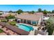 A picturesque backyard with a sparkling pool, covered patio, lush lawn, and privacy wall for outdoor enjoyment at 7648 W Mauna Loa Ln, Peoria, AZ 85381