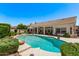 Lush backyard with a sparkling pool, an umbrella, and comfortable outdoor seating, perfect for relaxation at 7648 W Mauna Loa Ln, Peoria, AZ 85381