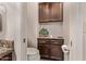 Half bathroom features granite countertops and decorative cabinets at 7648 W Mauna Loa Ln, Peoria, AZ 85381