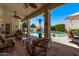 Relaxing covered patio area with comfortable seating, ceiling fans, and views of the inviting pool at 7648 W Mauna Loa Ln, Peoria, AZ 85381