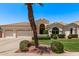 Charming home showcasing a manicured lawn, lush landscaping, and a three-car garage at 7648 W Mauna Loa Ln, Peoria, AZ 85381