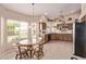 Bright kitchen with natural light, breakfast nook, tile flooring and wooden cabinets and granite countertops at 7648 W Mauna Loa Ln, Peoria, AZ 85381