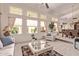 Bright and airy living room with multiple windows and stylish, neutral-toned furnishings at 7648 W Mauna Loa Ln, Peoria, AZ 85381