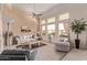 Bright living room with tall windows, neutral decor, and comfortable seating arrangements at 7648 W Mauna Loa Ln, Peoria, AZ 85381