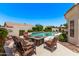 Inviting backyard pool area with a cozy outdoor seating arrangement around a modern fire pit at 7648 W Mauna Loa Ln, Peoria, AZ 85381