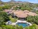 Stunning aerial view of estate featuring a pool, spa, lush landscaping, and a gorgeous home with a Spanish tile roof at 8329 N Ridgeview Dr, Paradise Valley, AZ 85253