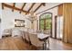 Elegant dining room with exposed wood beams, a grand chandelier, and a large window offering scenic outdoor views at 8329 N Ridgeview Dr, Paradise Valley, AZ 85253