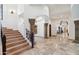 Elegant foyer featuring a wooden staircase, carved columns, and travertine flooring at 8329 N Ridgeview Dr, Paradise Valley, AZ 85253