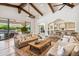 Living area with multiple sofas, vaulted ceilings with beams, and an open view to the pool at 8329 N Ridgeview Dr, Paradise Valley, AZ 85253