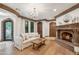 Comfortable living room with a stone fireplace, wood floors, decorative trim, and large windows at 8329 N Ridgeview Dr, Paradise Valley, AZ 85253