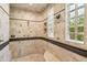 Spa-like shower featuring travertine walls, detailed trim work, glass block window, and multiple shower heads at 8329 N Ridgeview Dr, Paradise Valley, AZ 85253