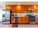 Well-equipped kitchen featuring stainless steel appliances, wooden cabinets, and tiled backsplash at 836 W Mitchell Dr, Phoenix, AZ 85013