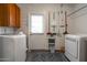 Functional laundry room with washer, dryer, storage cabinets, and backyard access at 836 W Mitchell Dr, Phoenix, AZ 85013