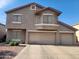 Inviting two-story home featuring a three car garage and classic architecture set beneath a bright blue sky at 9252 W Carol Ave, Peoria, AZ 85345