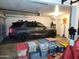 View of garage with SUV parked inside along with storage containers and baseball jersey at 9252 W Carol Ave, Peoria, AZ 85345