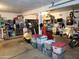 Spacious garage with stainless steel fridge, storage shelves, exercise equipment and storage containers at 9252 W Carol Ave, Peoria, AZ 85345