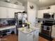 Modern kitchen featuring white cabinets, stainless steel appliances, island and an adjacent desk area at 9252 W Carol Ave, Peoria, AZ 85345