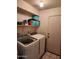 Functional laundry room with modern washer and dryer, shelf storage, and door to outside at 9252 W Carol Ave, Peoria, AZ 85345
