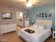 Comfortable main bedroom with ensuite bath, light wood floors, and beach themed artwork at 9252 W Carol Ave, Peoria, AZ 85345