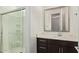 Well-lit bathroom showcasing a dark vanity, white countertop, and glass-enclosed shower at 1081 E Armstrong Way, Chandler, AZ 85286
