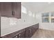 Extended kitchen with dark cabinets, white countertops, and subway tile backsplash, providing ample storage and counter space at 1081 E Armstrong Way, Chandler, AZ 85286
