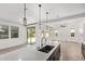 Bright open kitchen with a large island, stylish pendant lights, and sliding glass doors leading to the backyard at 1081 E Armstrong Way, Chandler, AZ 85286