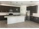 Modern kitchen with dark cabinetry, stainless steel appliances, and a large center island at 1081 E Armstrong Way, Chandler, AZ 85286