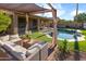 Inviting backyard with a pool, lounge chairs, covered seating area, and lush landscaping at 10909 W Chase Ln, Avondale, AZ 85323
